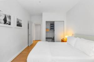 Un dormitorio blanco con una gran cama blanca. en Belltown's Flower Moon, near The Space Needle, en Seattle