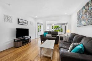 a living room with couches and a flat screen tv at Perfect FLL Location with Putting Green in Fort Lauderdale