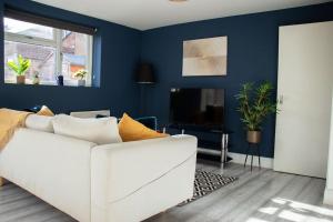 a living room with a white couch and a blue wall at Central Reading Contractor/Long Stay Discount in Reading