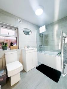 a bathroom with a toilet and a tub and a sink at Central Reading Contractor/Long Stay Discount in Reading
