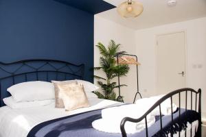 a bedroom with a bed with a blue accent wall at Central Reading Contractor/Long Stay Discount in Reading