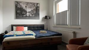 ein Schlafzimmer mit einem Bett mit einer Decke und einem Fenster in der Unterkunft Ney-Stay Ferienwohnung in Norderney