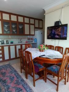 cocina con mesa con sillas y TV en Denize Sıfır Bahçeli Yalı en Gerze