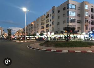 Appartements à AGADIR 10min de la plage في أغادير: شارع امام مبنى كبير بالليل