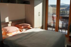 Schlafzimmer mit einem Bett und Blick auf einen Balkon in der Unterkunft Goldview Apartmani in Zlatibor