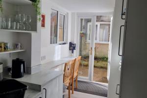 a kitchen with a table and chairs and a window at Dog-friendly Gosport town house sleeps 8 in Brockhurst