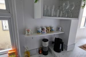 Eine Küche mit einem Haufen Tassen auf Regalen in der Unterkunft Dog-friendly Gosport town house sleeps 8 in Brockhurst