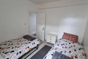 1 Schlafzimmer mit 2 nebeneinander liegenden Betten in der Unterkunft Dog-friendly Gosport town house sleeps 8 in Brockhurst