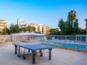 a ping pong table on a patio next to a pool at Nice Seaside Pool and Tennis in Nice