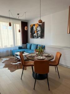 a living room with a table and a blue couch at Apartmán v Starom meste Sky Park s parkovaním in Bratislava