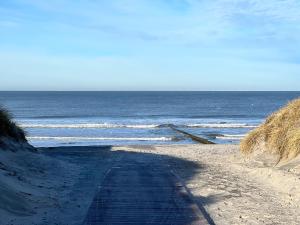 una carretera que conduce al océano en una playa en Ney-Stay Ferienwohnung en Norderney