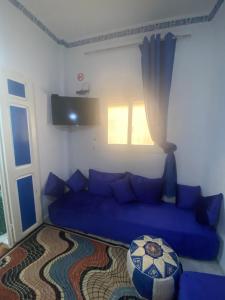 a blue couch in a living room with a window at Ibn Batouta House in Tangier