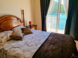 a bedroom with a large bed with a large window at Charming Holiday Home Lady Kate in Lastovo