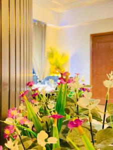 a bunch of flowers sitting in a room at Viceroy Royal Hotel Apartment Islamabad in Islamabad