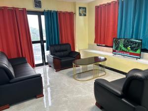 a waiting room with two chairs and a tv at Marine Apartments in Honiara