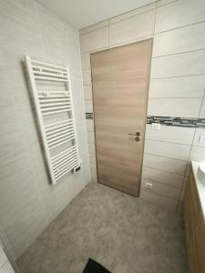 baño con puerta de madera y lavamanos en Appartement 6-8 personnes, gîte, climatisé, classé 3 étoiles, proche du zoo de Beauval et des châteaux de la Loire, en Selles-sur-Cher