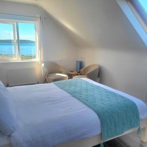 a bedroom with a bed and a large window at An Creagán Rooms in Inisheer