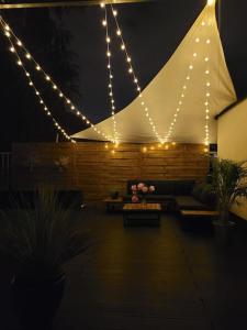 a patio with a tent with lights and a couch at Modern apartment with spacious backyard by Matt in Warsaw