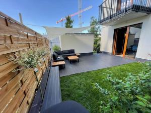 a backyard with a black couch and a wooden fence at Modern apartment with spacious backyard by Matt in Warsaw