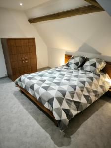 1 dormitorio con cama a cuadros en blanco y negro en Appartement 6-8 personnes, gîte, climatisé, classé 3 étoiles, proche du zoo de Beauval et des châteaux de la Loire, en Selles-sur-Cher