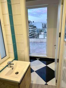 a bathroom with a sink and a window with a view at Paceville Sea view Penthouse with Jacuzzi! in St. Julianʼs
