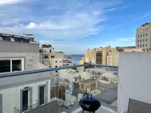 an apartment balcony with a view of a city at Paceville Sea view Penthouse with Jacuzzi! in St. Julianʼs