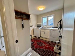 a bathroom with a washing machine and a sink at Brand new modern home in Breslau in Maryhill