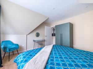 a bedroom with a blue bed and a blue chair at Charmant Cocon au Neudorf in Strasbourg