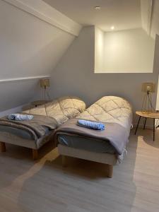 two twin beds in a room with a attic at Family cottage 4 chambres in Bourbourg