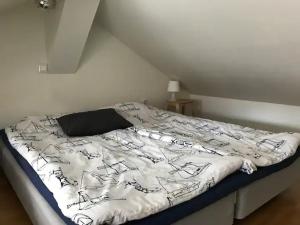 uma cama com um edredão preto e branco num quarto em Lilla Gäststugan em Uppsala
