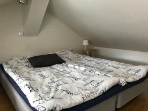 a bed with a black and white comforter in a room at Lilla Gäststugan in Uppsala