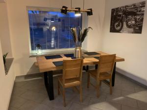 a dining room table with chairs and a vase with flowers at Home - Ostružina in Olomouc