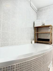 a white bath tub in a bathroom with white tiles at Maison cocooning à 6 mn de Honfleur in La Rivière-Saint-Sauveur +18 photos