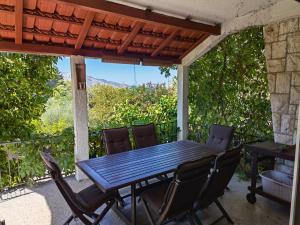 einen Holztisch und Stühle auf einer Terrasse in der Unterkunft Jees Exclusive Apartments Hvar in Stari Grad