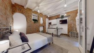 1 dormitorio con cama y pared de ladrillo en La Casetta in colonne, en Milán