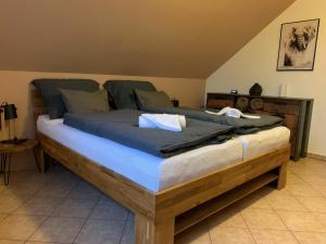 um quarto com uma grande cama de madeira com lençóis azuis em Home - Ostružina em Olomouc