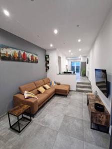 a living room with a couch and a table at charmante maison 2 chambres, entièrement rénovée in Jeuk
