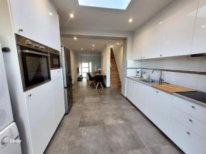 una cocina con armarios blancos y una mesa. en charmante maison 2 chambres, entièrement rénovée, 