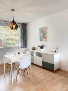 a white dining room with a table and chairs at Wohnliches Design Apartment in schöner Lage nahe Ulm & Science Park in Blaustein