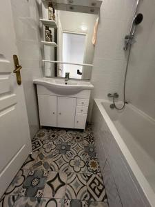 ein Badezimmer mit einem Waschbecken, einem Spiegel und einer Badewanne in der Unterkunft Appartement tout équipé proche plages in Fos-sur-Mer