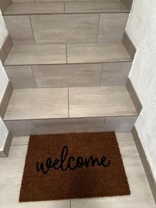 una alfombra de bienvenida en el suelo de una escalera en Appartement tout équipé proche plages, en Fos-sur-Mer