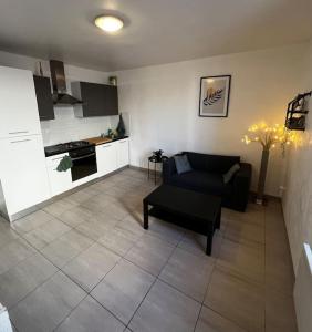 sala de estar con sofá y cocina en Appartement tout équipé proche plages, en Fos-sur-Mer
