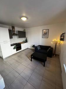 sala de estar con sofá y cocina en Appartement tout équipé proche plages, en Fos-sur-Mer