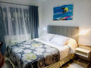 ein Schlafzimmer mit einem Bett und einem Wandgemälde in der Unterkunft Apart Ruta 40 in El Chalten