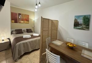 ein Schlafzimmer mit einem Bett und einem Schreibtisch sowie einem Tisch mit einer Obstschale in der Unterkunft B&B I Mulini in Santa Maria del Molise