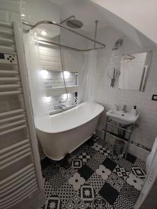 a white bathroom with a tub and a sink at Aux portes de Lyon in Saint-Fons