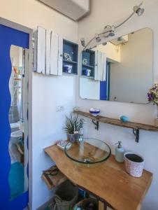bagno con lavabo in vetro e specchio di Your seaside flat a Porto Santo Stefano