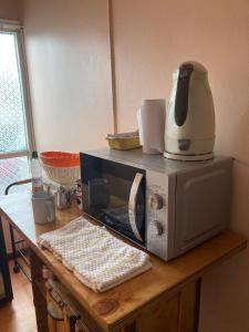 a microwave sitting on top of a wooden table at hospedaje 12 de octubre in Coihaique