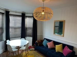 ein Wohnzimmer mit einem blauen Sofa und einem Tisch in der Unterkunft Stylish, Modern & refurbished flat, 1.5m beach in Southend-on-Sea