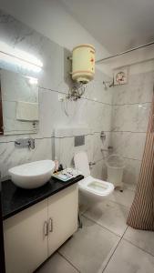 une salle de bain avec un lavabo et des toilettes dans l'établissement The Ivory Pine, à Shimla